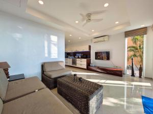 a living room with a couch and a table at Five Palms Beachfront Villa - by KohChangVillas in Ko Chang
