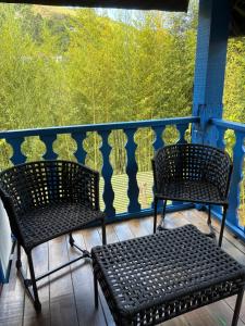 two chairs on a balcony with a view of trees at Pousada Dom Luiz in Ouro Preto