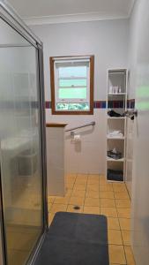 a bathroom with a shower and a window at 2 Long between breaks in Coffs Harbour