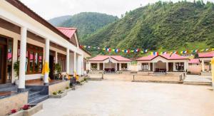 a group of buildings with mountains in the background at Rivero Resort in Dirang Dzong