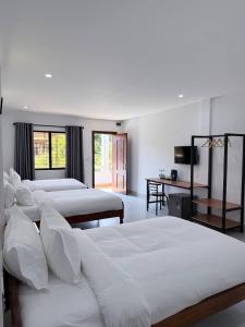 a hotel room with four beds and a television at For Rest Inn in Phumĭ Réach Born (2)