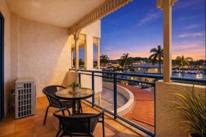 a balcony with a table and chairs and a view of the water at The Anchorage Escape Studio - Steps away from City, Ferry and Stadium in Townsville in Townsville