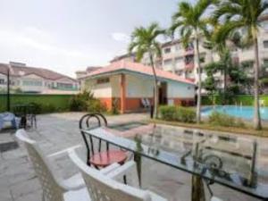 un patio avec une table et des chaises et une piscine dans l'établissement Hotel Casamas, à Malacca