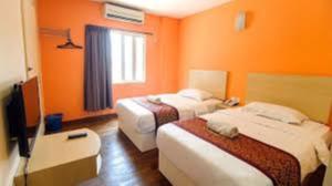 une chambre d'hôtel avec deux lits et une télévision dans l'établissement Hotel Casamas, à Malacca
