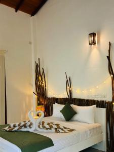 En eller flere senge i et værelse på Papaya Hikkaduwa