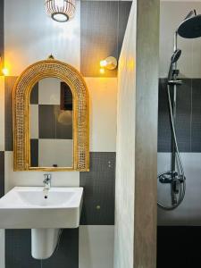une salle de bains avec un lavabo et un miroir dans l'établissement Papaya Hikkaduwa, à Hikkaduwa