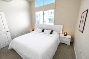 a white bedroom with a large white bed and a window at Luxury Residence Loft 3 Beds with Pool and Gym in Los Angeles +18 photos