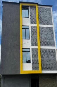ein Gebäude mit einem gelben Streifen auf der Seite in der Unterkunft Haití Hotel B in Tumaco