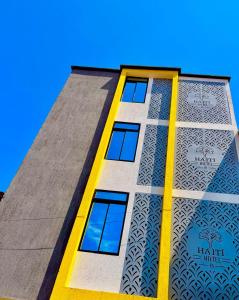 ein hohes Gebäude mit gelben und blauen Fenstern in der Unterkunft Haití Hotel B in Tumaco + 9 Fotos