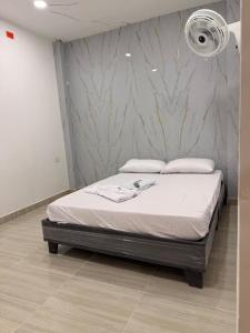 ein Bett in einem Schlafzimmer mit einer Marmorwand in der Unterkunft Haití Hotel B in Tumaco