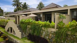 a house with a stone retaining wall and stairs at SVARGA RENJANA ViLLA in Lombok