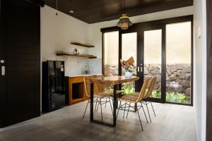 a kitchen with a table and chairs in a room at SVARGA RENJANA ViLLA in Lombok