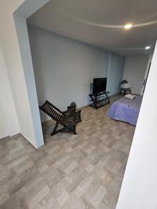 a living room with a bench and a flat screen tv at Alpha1 in Roldanillo