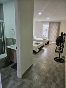 a room with a bed and a bathroom with a sink at Alpha1 in Roldanillo