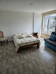 una camera da letto con un letto, un divano e una finestra di Alpha1 a Roldanillo Altre 41 foto