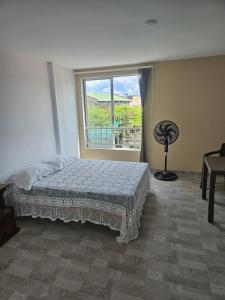 una camera da letto con un letto davanti a una finestra di Alpha1 a Roldanillo