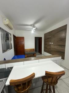 a kitchen with a white table and two chairs at Villa Caraguá Apartamentos in Caraguatatuba
