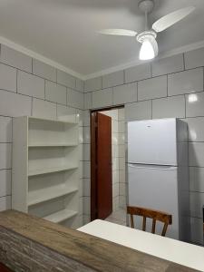 a kitchen with a refrigerator and a table in it at Villa Caraguá Apartamentos in Caraguatatuba