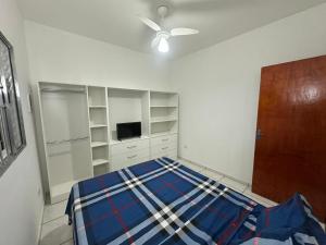 a bedroom with a bed and a ceiling fan at Villa Caraguá Apartamentos in Caraguatatuba +27 photos
