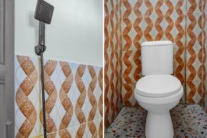 a bathroom with a toilet with a sign next to it at Hotel O Roda Inn in Padang +29 photos