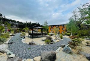 ein Garten mit einem Pavillon und einem Gebäude in der Unterkunft Fujinomori Hotel in Fujikawaguchiko