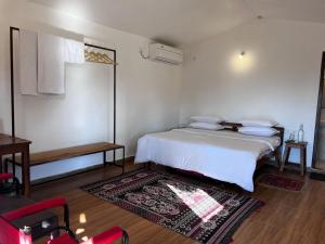 une chambre avec un lit blanc et un tapis dans l'établissement Home in the Jungle, à Seonī