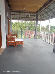 een lege veranda met een bankje en een speeltuin bij Uoemah gunung baturaden in Baturaden