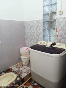 een badkamer met een bad en een toilet. bij Uoemah gunung baturaden in Baturaden