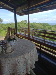 a table with flowers on it with a bench at Hilltop Cottage in Cabulihan