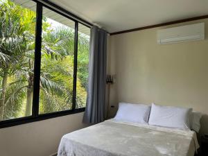 a bedroom with a bed and a large window at Phines Place in Panglao