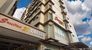 ein Gebäude mit einem Kaffeeschild auf der Seite in der Unterkunft SMALLVILLE 21 HOTEL in Iloilo City