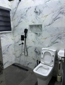 een badkamer met een toilet en een telefoon aan de muur bij bedandchuckle in Kaduna