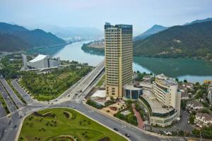 eine Luftansicht eines großen Gebäudes neben einem Fluss in der Unterkunft Jiande Peninsula Kaihao Hotel in Thousand Island Lake