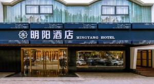 een winkel voor een gebouw met borden erop bij Ming Yang Hotel in Haikou