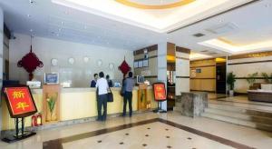 twee mensen aan de balie van een restaurant bij Ming Yang Hotel in Haikou