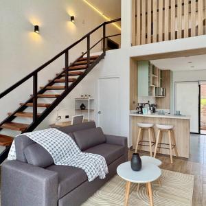 a living room with a couch and a staircase at Tiny House con Jacuzzi, Fogata y Starlink in Anta