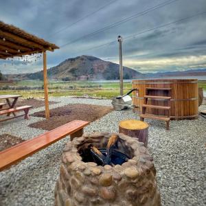 a outdoor grill with a bench and a table and a mountain at Tiny House con Jacuzzi, Fogata y Starlink in Anta