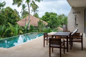 - une table à manger et des chaises à côté de la piscine dans l'établissement Kuul villa 4 - Seaview & Stylish villa, à Baan Tai