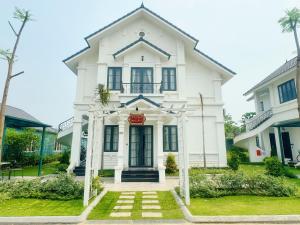 a white house with a sign on it at Vườn vua resort- Sunvillas in Ðồng Phú