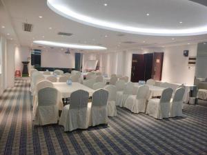 una sala per banchetti con tavoli e sedie bianchi di Wanyi Hotel a Dongguan