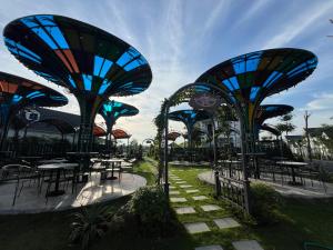 a group of tables and chairs in a park at Vườn vua resort- Sunvillas in Ðồng Phú +21 photos