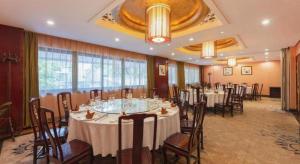 une salle de banquet avec des tables et des chaises dans une pièce dans l'établissement Shaoxing Yintai Hotel, à Shaoxing