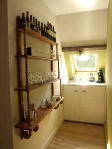 a kitchen with shelves with glasses and a sink at B&B Pastorie van Merkem in Merkem