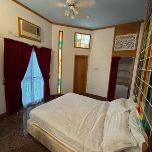 ein Schlafzimmer mit einem weißen Bett und einem Fenster in der Unterkunft Qurum Heights Hotel in Muscat