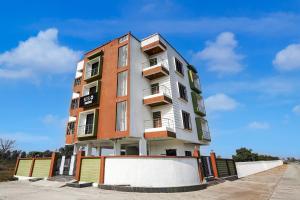 a tall apartment building in front of a blue sky at Hotel O Ring Road Nagpur Formerly Glory Inn in Khāpri