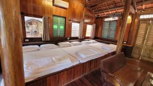een kamer met twee bedden in een houten boot bij Nhà Sen Phước Hải in Hội Mỹ