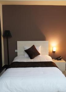 een slaapkamer met een groot wit bed met een kussen bij Herat Star Hotel in Herat