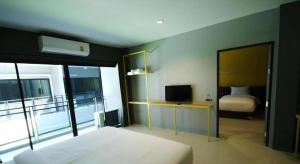 une chambre avec un lit et une pièce avec une fenêtre dans l'établissement Seven bee boutique hotel, à Surin