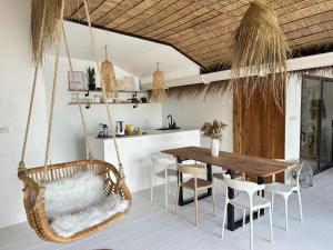 - une salle à manger avec une balançoire, une table et des chaises dans l'établissement Sama Beach Resort by Munchies Resort, à Baan Tai