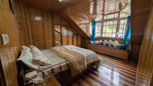 a bedroom with a bed in a wooden cabin at Foggy Hill's Darjeeling in Darjeeling